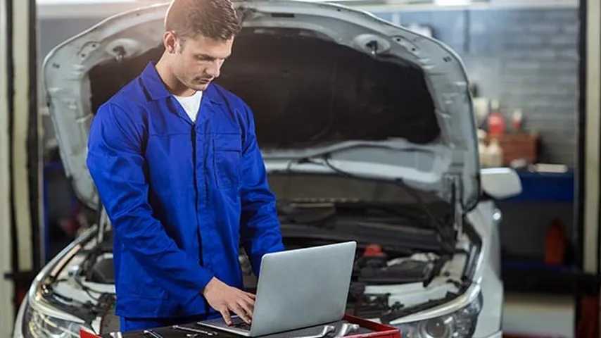 Mecánico analizando parámetros de un coche en el taller. (Foto: Freepik)